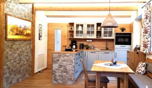 a kitchen with a table and a stone wall at Alpenchalet-Chiemgau in Marquartstein