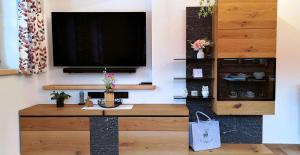 a living room with a television on a wall at Alpenchalet-Chiemgau in Marquartstein