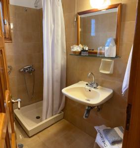 a bathroom with a sink and a shower with a shower curtain at HOTEL MARI Metsovo in Metsovo