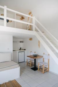 a room with a loft bed and a table and chairs at Nissos Suites in Apollonia