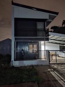 a white building with a balcony and a fence at Nancy's Place in Caniton