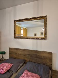 a mirror on the wall of a bedroom with two beds at Monelly Apartman in Komárno