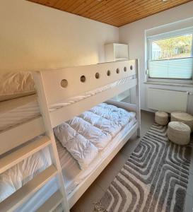 a white bunk bed in a room with a window at ZweiundMeer Bungalow 1 in Wiek auf Rügen