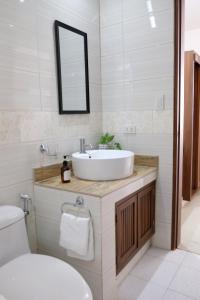 a bathroom with a sink and a toilet and a mirror at Sundown Resort & Austrian Pension House in Boracay +26 photos