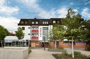 a white building with a black roof at RENOVIERT XZLLENZ 50'' Smart TV, Parken, 24h digitaler Check In und Zugang, Küche in Oberasbach