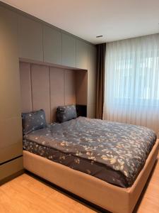 a bedroom with a large bed with a headboard at Skyline Exclusive 2 in Peje