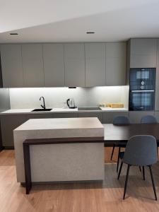 a kitchen with white cabinets and a table and chairs at Skyline Exclusive 2 in Peje