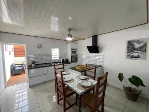 a kitchen with a table and chairs in a room at Les volets de l'océan in Saint-Philippe