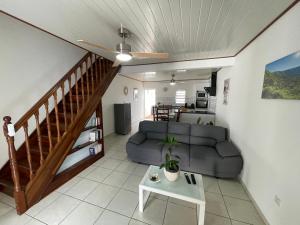a living room with a couch and a table at Les volets de l'océan in Saint-Philippe