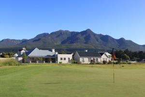 a golf hole with a house and mountains in the background at Kingswood Close in George