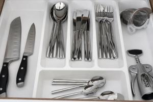 a drawer filled with silver utensils and spoons at Waves 60 Infinity in Mamaia Sat/Năvodari