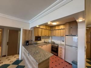 a kitchen with wooden cabinets and a white refrigerator at Gleem Sea View 8 in Alexandria
