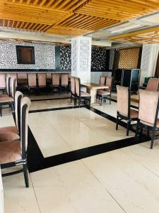 a dining room with chairs and tables and a tv at Hotel De Park in Shimla +13 photos