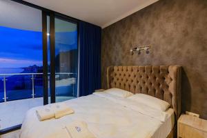 a bedroom with a large bed with a large window at Panoramic Sea Apartment in Kvariati