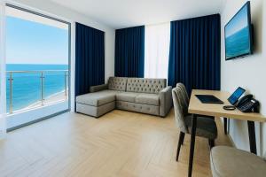 a living room with a couch and a table and a window at Panoramic Sea Apartment in Kvariati