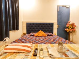 a bed with an orange pillow on it with a table at TIP TOP PG - Paying Guest in Phagwāra