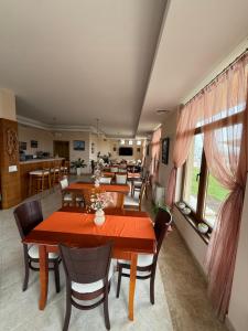 a dining room with tables and chairs and a kitchen at Златна люспа in Bŭlgarevo