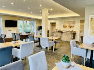 a restaurant with tables and chairs and a kitchen at Weinbergs Loge in Ernst