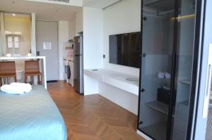 a room with a bed and a tv and a kitchen at The Sunshine Beach Resort Studio in Layan Beach +19 photos