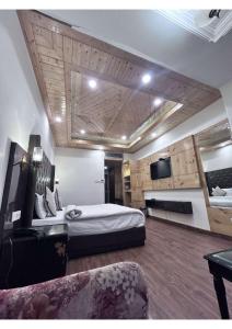 a bedroom with a bed and a tv and a couch at Hotel De Park in Shimla