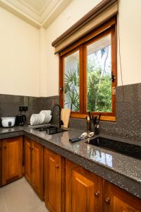a kitchen with a counter top and a window at Orchid Resort By Paradise in Habaraduwa Central