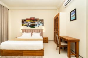 a bedroom with a bed and a desk and a table at Orchid Resort By Paradise in Habaraduwa Central +16 photos