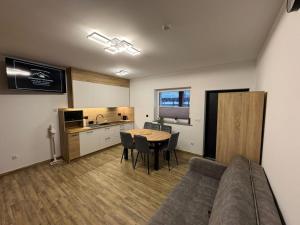 a living room with a couch and a table and a kitchen at Apartamenty w Kotlinie in Lądek-Zdrój