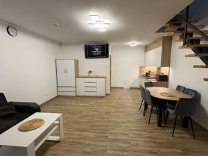 a living room with a table and chairs and a kitchen at Apartamenty w Kotlinie in Lądek-Zdrój