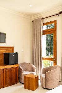 a living room with two chairs and a television at Orchid Resort By Paradise in Habaraduwa Central