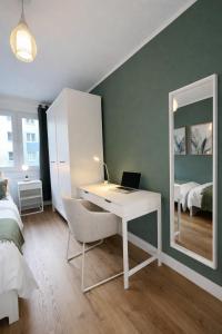 a bedroom with a desk with a laptop and a mirror at Großzügiges Apartment am Limbecker Platz mit Cafés, Top Anbindung & Netflix in Essen