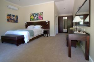 a hotel room with a bed and a desk at Clos Malverne Wine Estate in Stellenbosch +46 photos