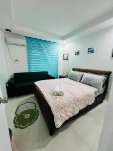 a bedroom with a large bed and a couch at Poolside Condo in Subic Bay in Olongapo