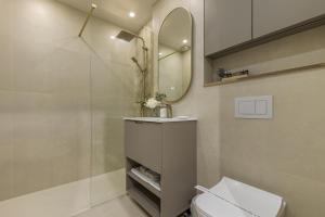a bathroom with a shower and a toilet and a mirror at Moon Apartments in Cluj-Napoca