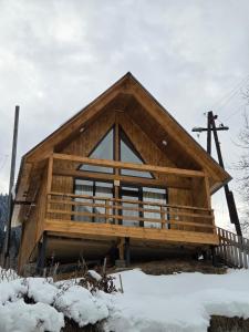 a log cabin with a gambrel roof in the snow at Lasha's Cottage in Mestia