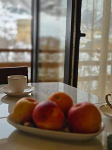 a plate of apples and oranges on a table at Lasha's Cottage in Mestia