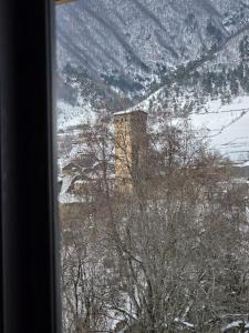 a view of a snow covered mountain from a window at Lasha's Cottage in Mestia