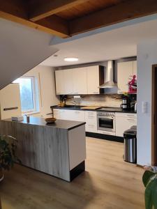 a large kitchen with white cabinets and a counter top at FW zur Gemütlichkeit in Hirschaid