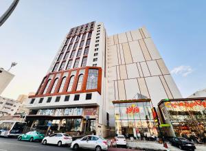 a tall building with cars parked in front of it at فندق قرى Qira Hotel in Mecca