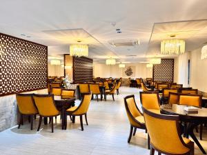 a restaurant with tables and chairs in a room at فندق قرى Qira Hotel in Mecca
