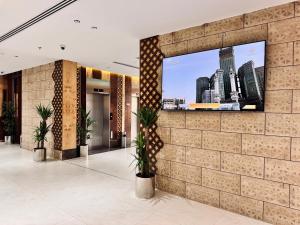 a lobby with a flat screen tv on a brick wall at فندق قرى Qira Hotel in Mecca