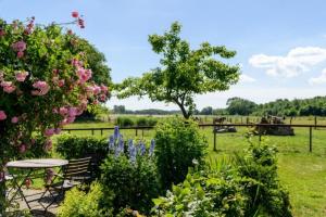 a garden with a table and flowers and a field at FerienGut Gaarz - Im Park 3 in Göhl