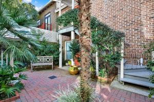 a courtyard with a bench and a brick building at Crawford Carriage House in Savannah