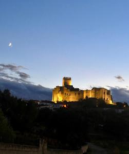 a castle sitting on top of a hill at night at Apartamento La Hera in Belvis de Monroy