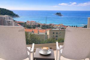 a cup of coffee sitting on a table on a balcony at Villa Blue Vista Meerblick mit Jacuzzi in Petrovac na Moru