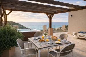 a table with food on a patio with a view of the ocean at Villa Blue Vista Meerblick mit Jacuzzi in Petrovac na Moru
