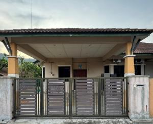 a house with a gate in front of it at Ayu Homestay Kuantan in Beserah