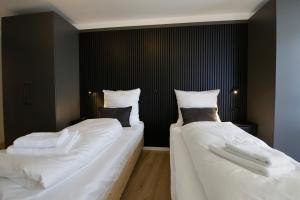 two beds in a room with white sheets and pillows at 3-2-1meins Röntgen bis 3 Pers DTV 4 Sterne Parkplatz WLAN Self Check-in in Remscheid