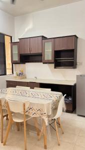 a kitchen with a table with chairs and a refrigerator at Ayu Homestay Kuantan in Beserah