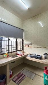 a kitchen with a sink and a stove at Ayu Homestay Kuantan in Beserah +15 photos