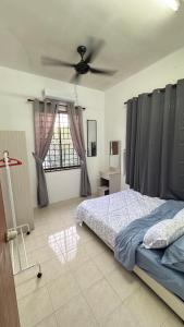 a bedroom with a bed and a ceiling fan at Ayu Homestay Kuantan in Beserah